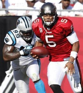 Tampa Bay Buccaneers quarterback Josh Freeman runs upfield chased by Carolina Panthers defensive end Charles Johnson uring the first half of their NFL football game in Tampa